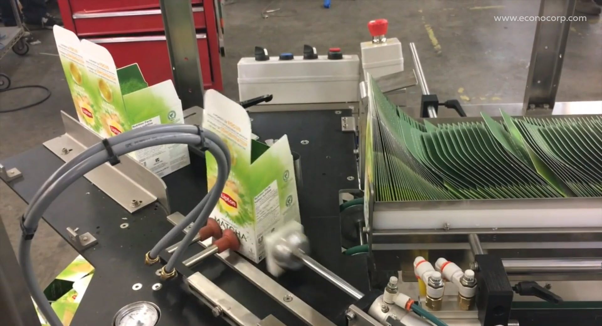 Auto bottom erector machine gathering and opening boxes from a supply magazine via a rotary vacuum system.